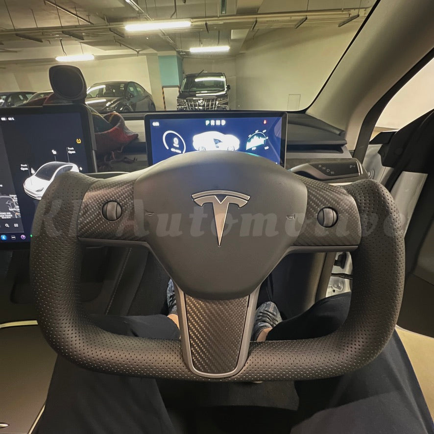 Matte carbon fiber steering wheel with perforated leather grips and center emblem